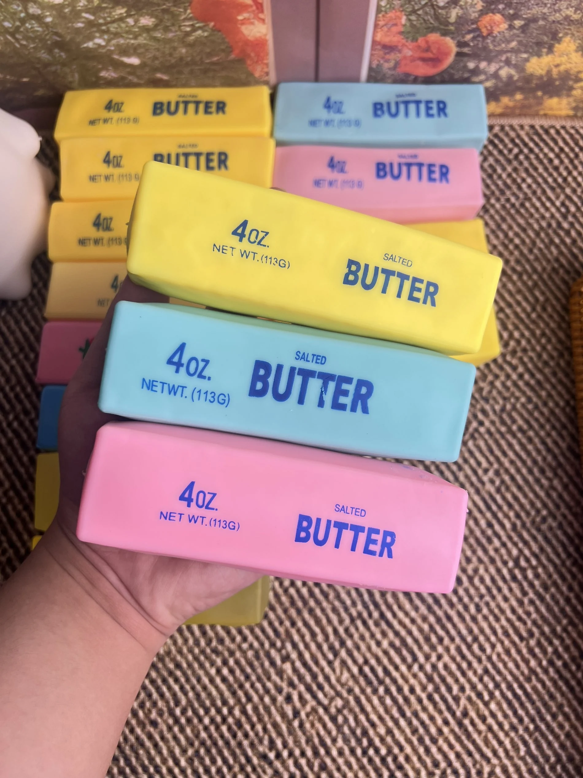 Yellow, blue and pink butter squishies held in hand